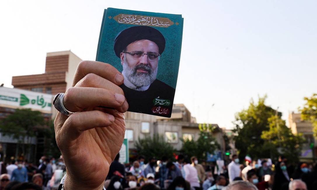 A supporter of conservative Iranian presidential candidate Ebrahim Raisi raises his picture during a rally in the capital, Tehran, ahead of the presidential elections in the Islamic Republic.  Photo: ATTA KENARE / AFP