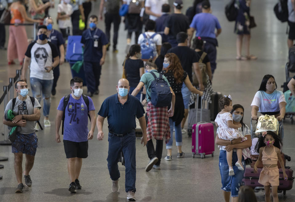 In the midst of the Covit-19 epidemic, on Wednesday, December 30, 2020, passengers walk into the passenger terminal at the Guarulhos International Airport near Sao Paulo, Brazil.  Despite the rising number of infections in the country, Brazilians are flocking to airports and taking to the highways to take friends and loved ones to the New Year and take advantage of the long weekends.  (AB Photo / Andre Penner)