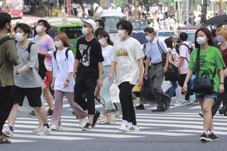 People wearing face masks to help protect against the spread of the coronavirus walk through an intersection in Tokyo on Monday, August 30, 2021 (AP Photo/Koji Sasahara)