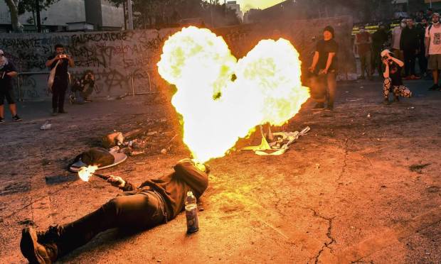 A protester blows fire during a protest to mark the second anniversary of the civil uprising against social inequality in Santiago.