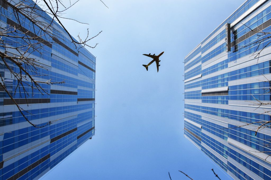 Plane near the blue and gray building