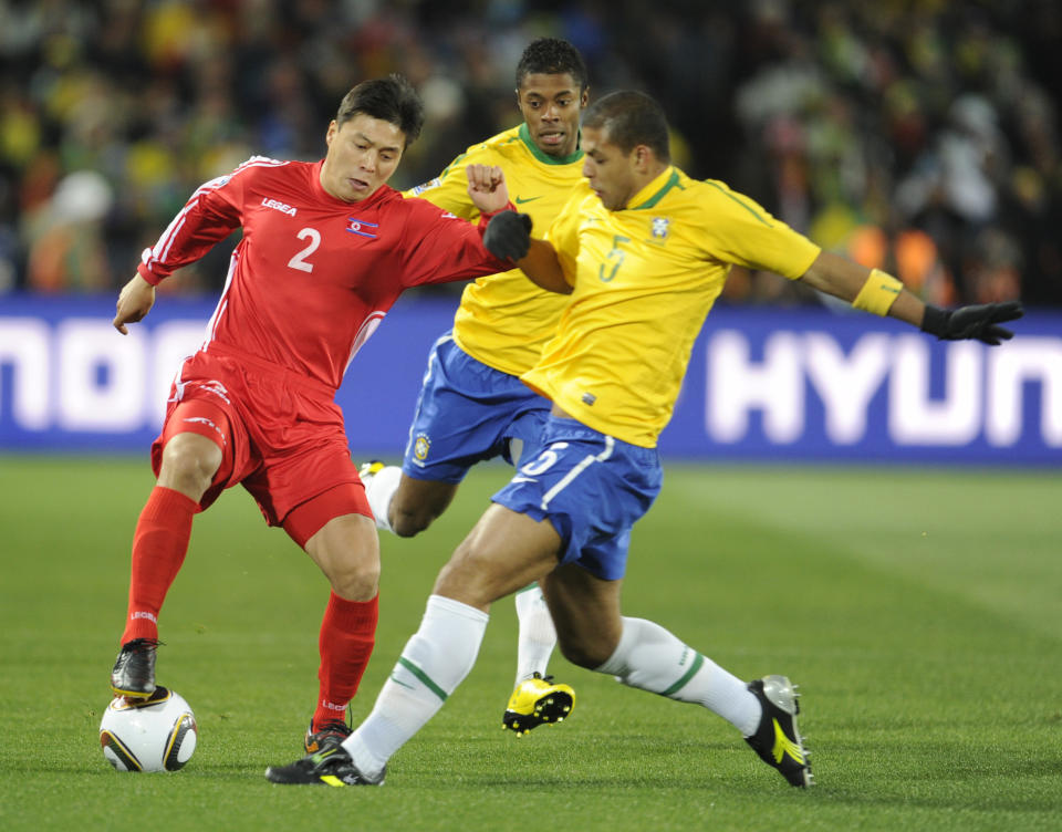 North Korea defender Cha Jong Hyuk (left) fights for the ball with Brazilian midfielder Felipe Melo during the first round of Group G of the 2010 FIFA World Cup Brazil vs Brazil match.  North Korea on June 15, 2010 at Ellis Park in Johannesburg.  DO NOT USE PHOTO ONLY MOBILE PHOTO / PHILIPPE MARCOU - AFP PHOTO / PIERRE-PHILIPPE MARCOU (Picture of PIERRE-PHILIPPE MARCOU / AFP must be read via Getty Images)