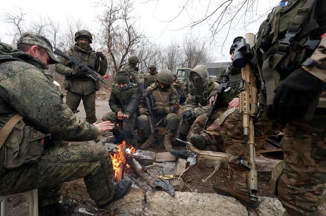 Members of pro-Russian forces in illegal uniforms gather around a fire in the separatist-held settlement of Mykolaivka (Nikolaevka) as Russia continues its offensive on Ukraine.