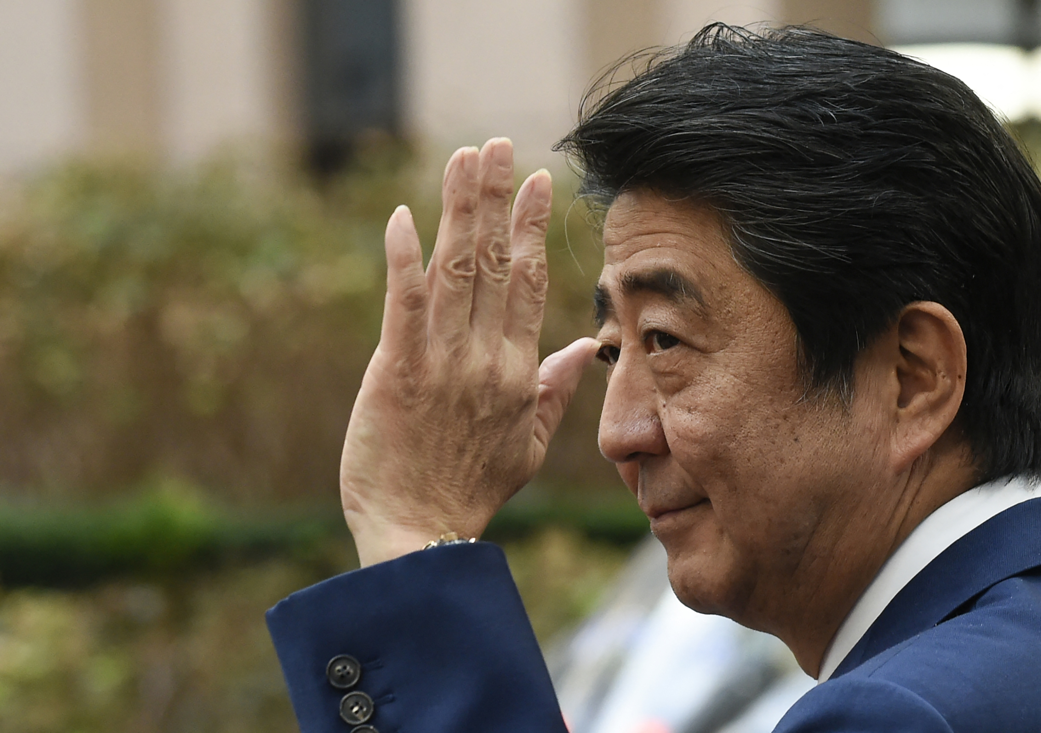 (Files) In this file photo taken on October 19, 2018, Japanese Prime Minister Shinzo Abe waves as he leaves after attending an EU-Korea summit meeting at the European Council in Brussels.  Abe was confirmed dead after being shot at an election event in Nara on July 8, 2022, Japanese broadcaster NHK and Jiji news agency reported.  (Photo by John Theiss/AFP)