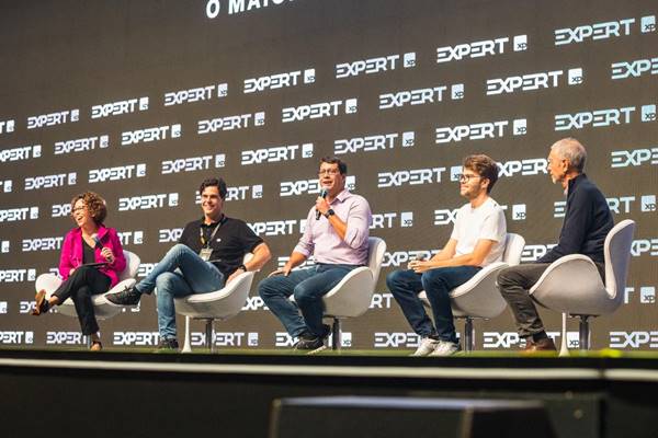 Color picture of five people sitting on white chairs