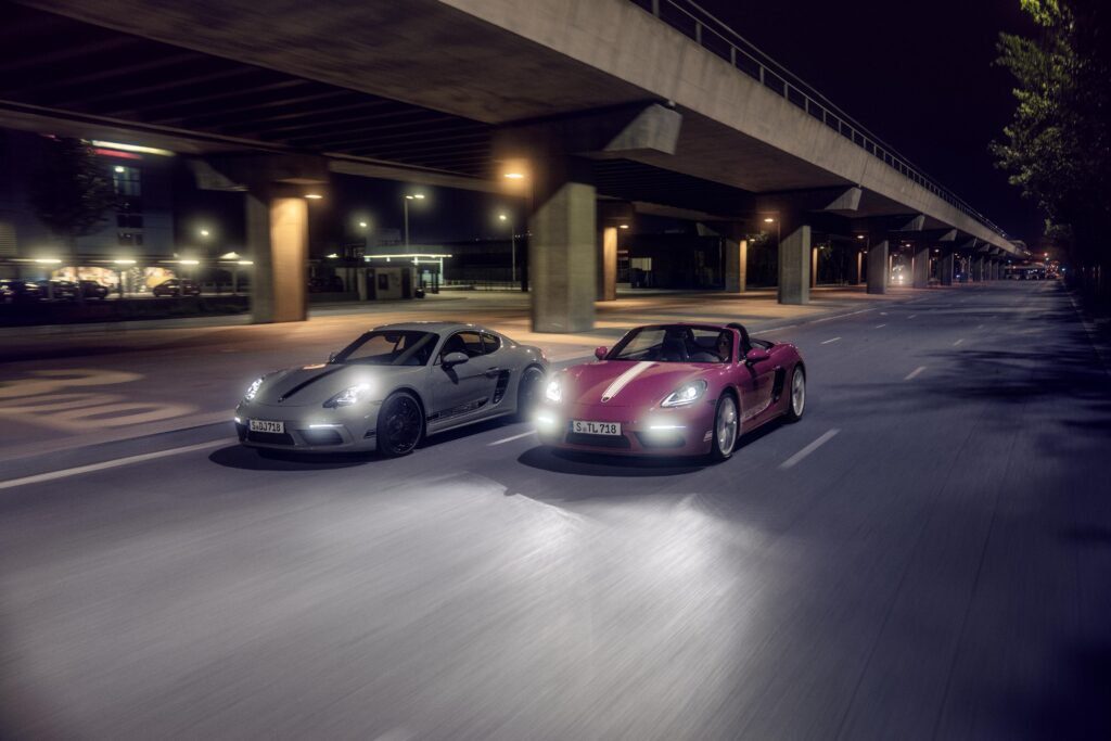 The Porsche 718 Boxster Style Edition and Cayman Style Edition are seen from above and diagonally across the road. 